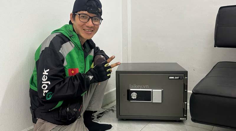 Thợ khóa kiểm tra bảng điều khiển két mini khi người dùng không mở được. Hình ảnh minh họa và không bao gồm thao tác mở.