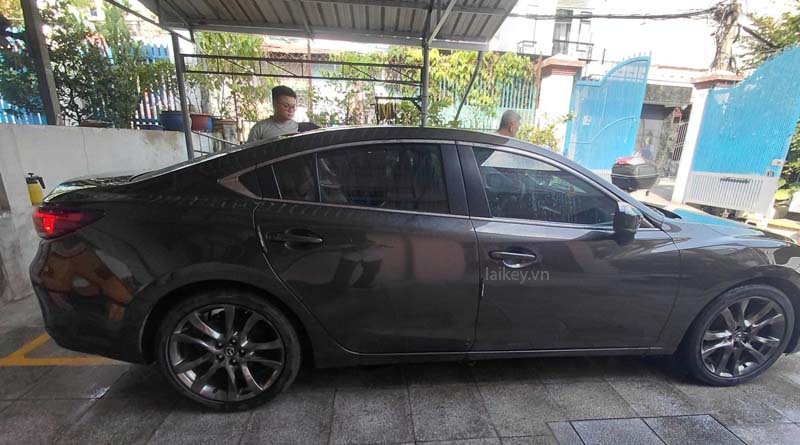 Kỹ thuật viên kiểm tra tình trạng cửa ô tô khi khách gặp sự cố không mở được từ bên ngoài. Hình ảnh minh họa và không bao gồm thao tác mở.