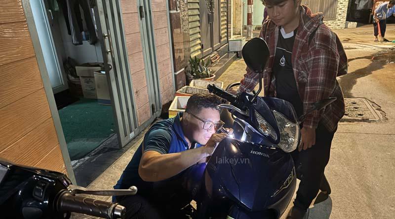 Thợ khóa kiểm tra ổ khóa xe máy để xác định vị trí mảnh chìa bị gãy. Hình ảnh minh họa và không bao gồm thao tác mở.