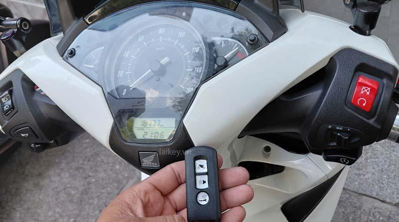 Thợ khóa quan sát cụm đồng hồ và đèn cảnh báo Smartkey Honda để đánh giá trạng thái hệ thống khóa điện tử. Hình ảnh minh họa và không bao gồm thao tác mở.