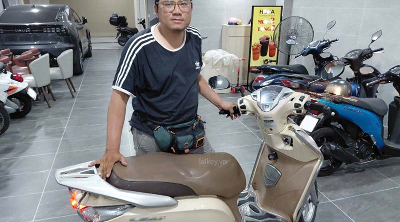 Thợ khóa quan sát tư thế dựng xe máy để xác định yếu tố lực tác động làm khóa chống trộm bị kẹt. Hình ảnh minh họa và không bao gồm thao tác mở.