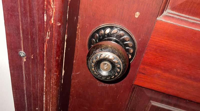 Kỹ thuật viên kiểm tra ổ khóa cửa gỗ bằng quan sát bên ngoài. Hình minh họa dịch vụ, không bao gồm thao tác mở khóa.